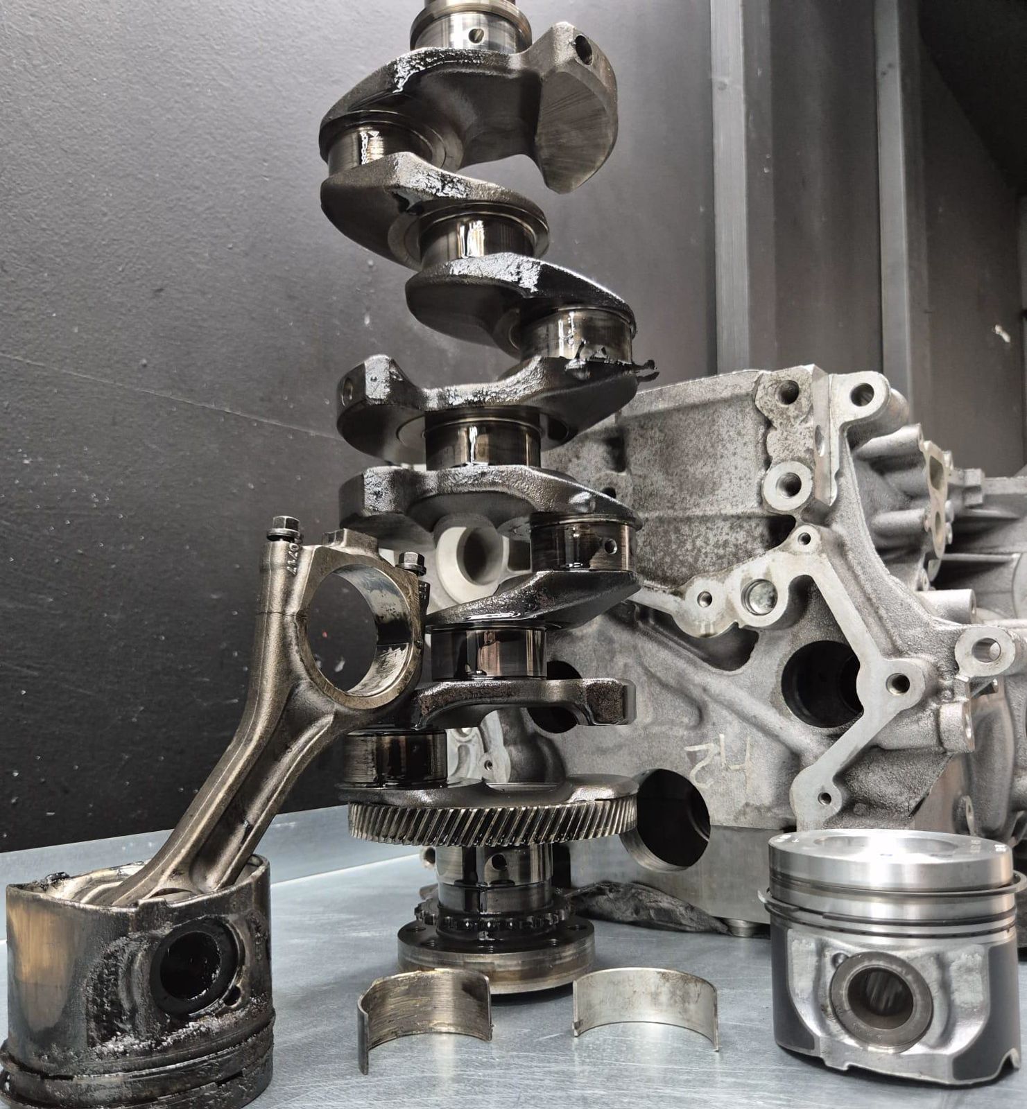 Crankshaft and pistons laid out for an engine rebuild