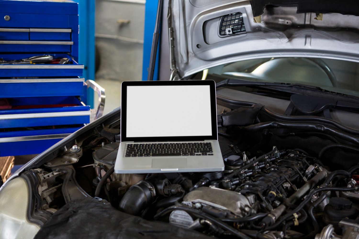 Laptop running diagnostic software connected to an engine